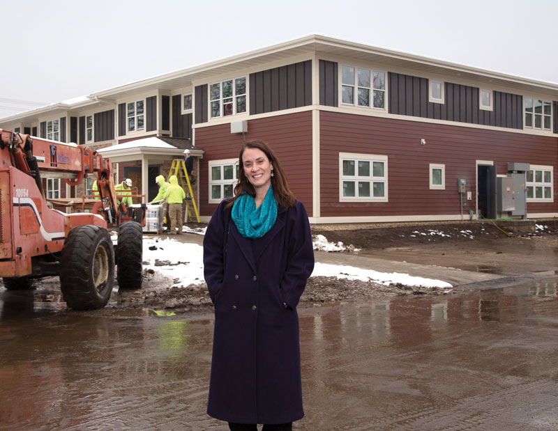 Karla Thennes, Executive Director of Porchlight, stands in front of a new development with 16 efficiency apartments to provide people with supportive, permanent housing. The MGE Foundation donated to the capital campaign and to help Porchlight fulfill its mission to decrease the homeless population.