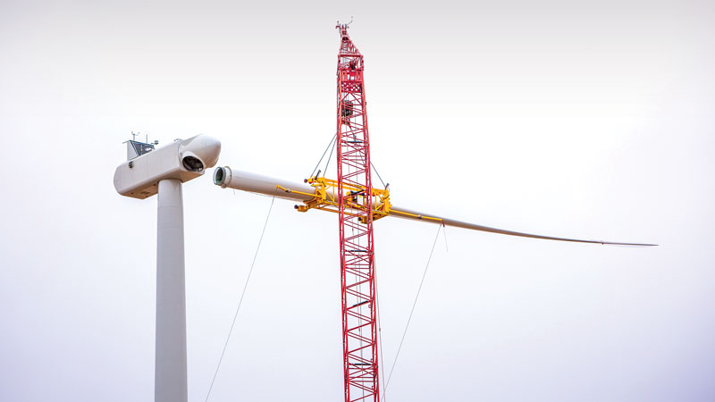 A crane places a blade on the hub of one of MGE's 33 Vestas turbines at the company's new Saratoga Wind Farm in northeast Iowa. The tips of the blades at Saratoga reach nearly 500 feet high in the air