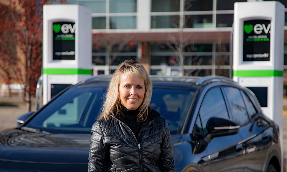 Debbie Branson in front of EV chargers