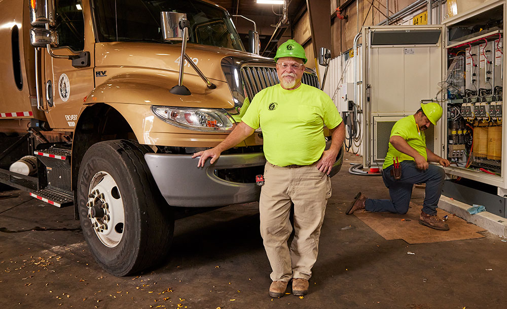 Matt Parks, Master Electrician, and Mathias Kranz, Journeyman Electrician, both with the City of Madison Engineering Division, finish installation of a charging station to power electric refuse trucks,