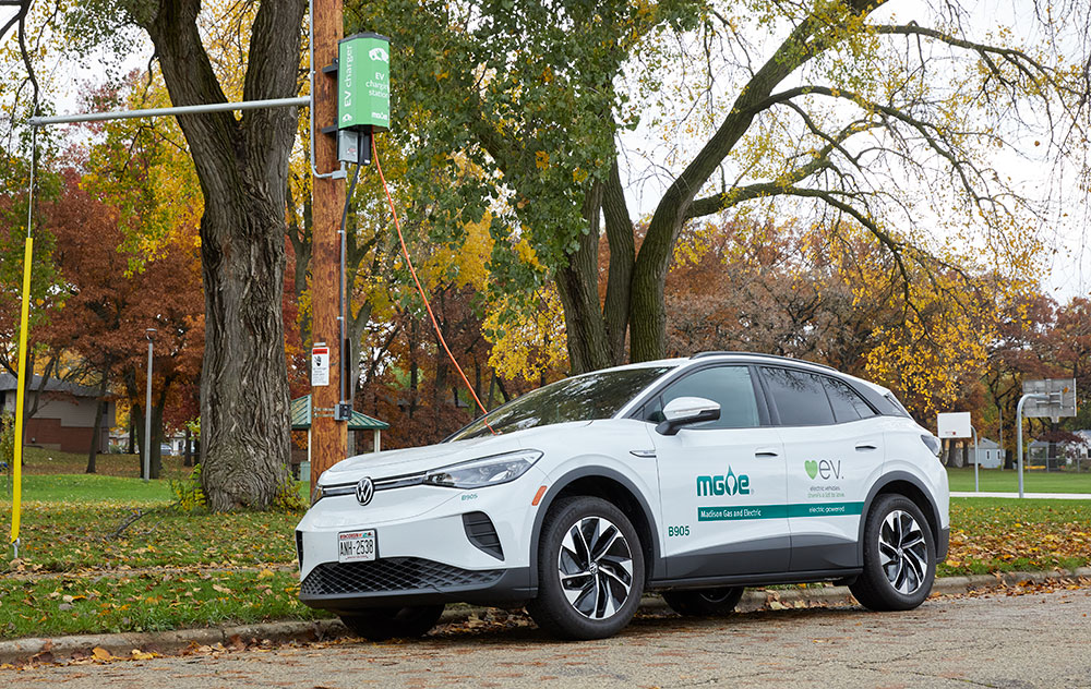 White MGE EV charging at a pole-mounted charger.