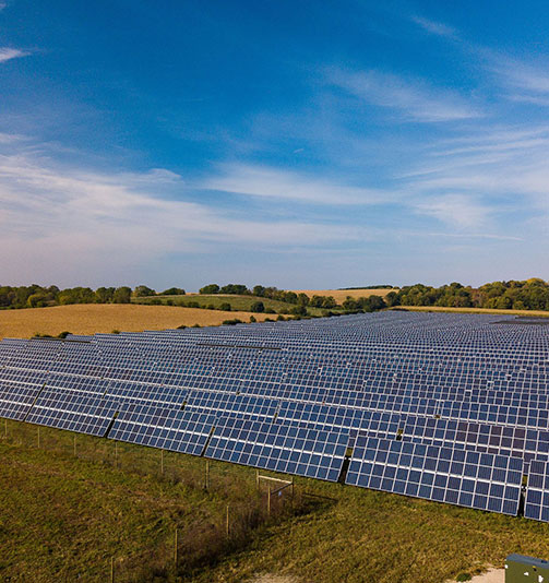 Wide shot of large solar field on sunny early fall day.